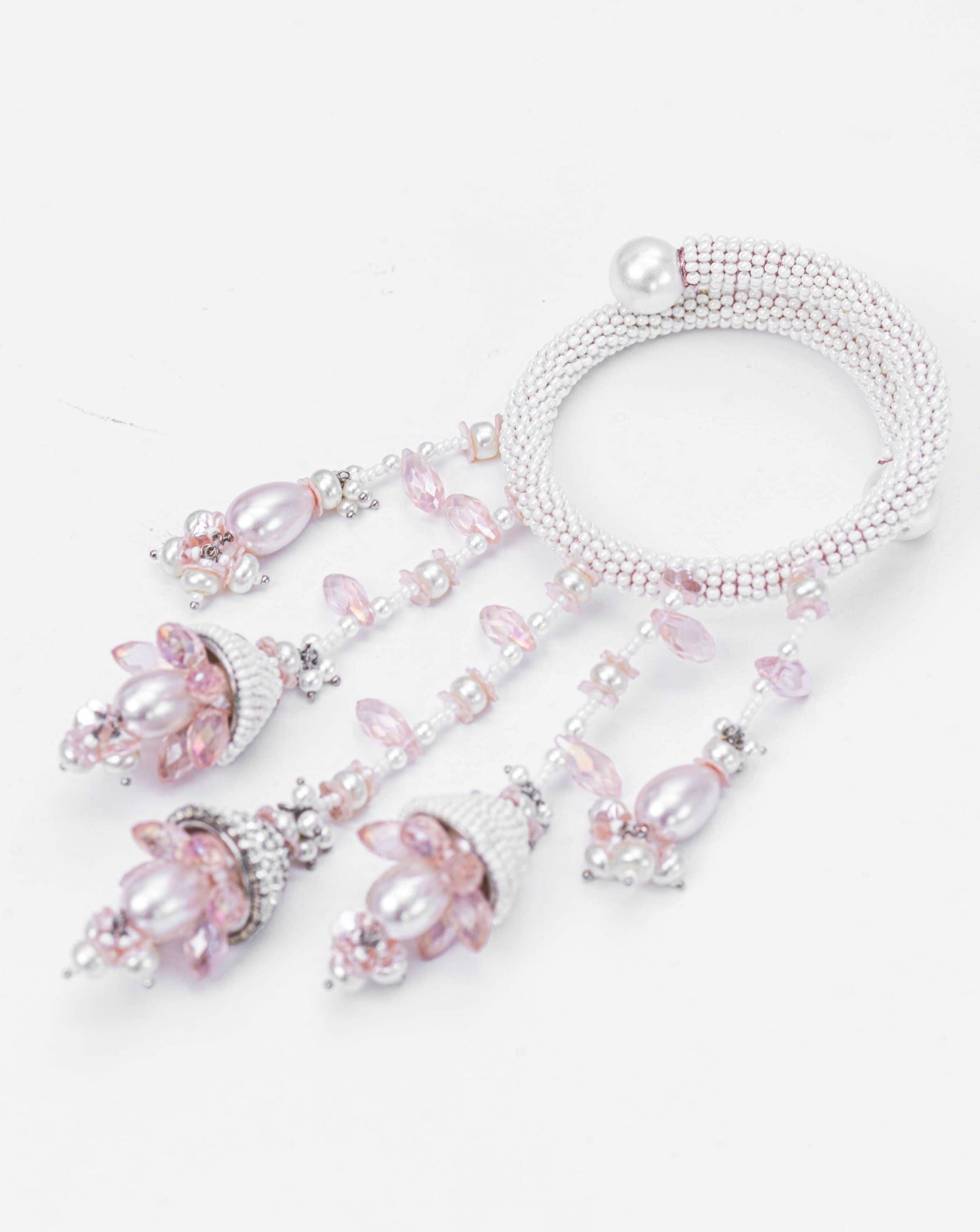 A pink and white beaded bracelet with floral and pearl embellishments, part of the AMAMA RAKHI collection.