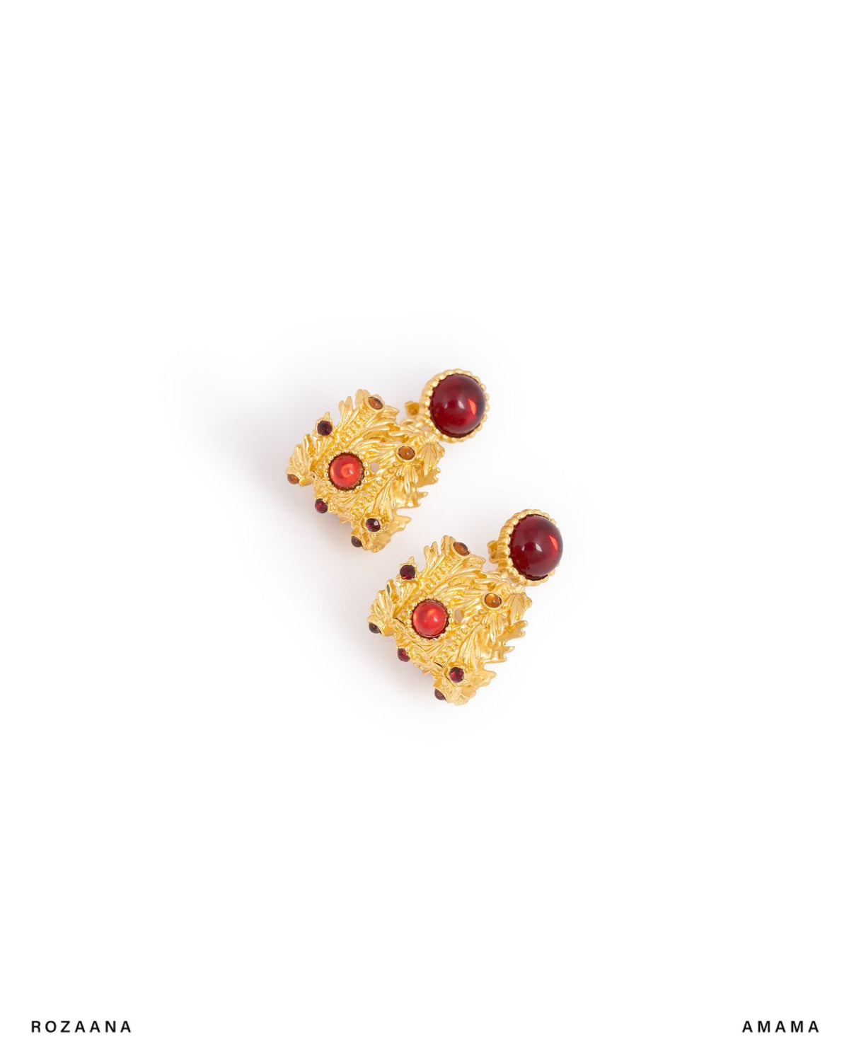 Pair of gold earrings with red stones on a white background