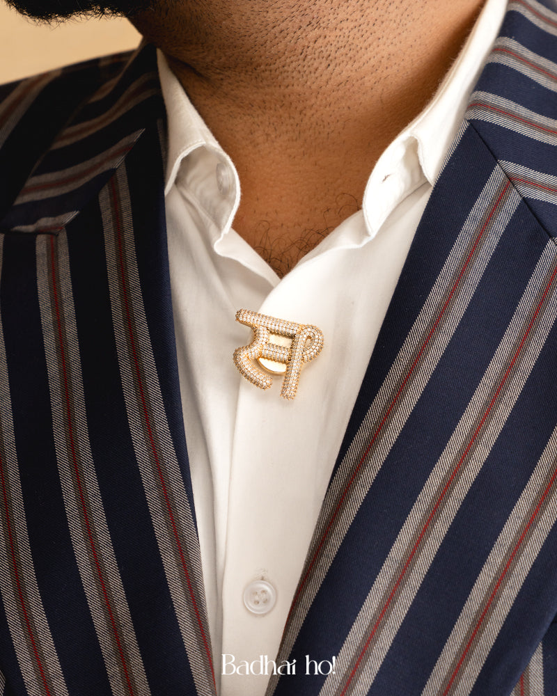 Close-up of a person wearing a striped suit with a decorative brooch on a beige background

