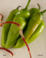 Bracelet with chili pepper design on green peppers